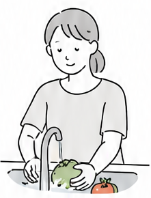 蛇口の水で野菜を洗う女性